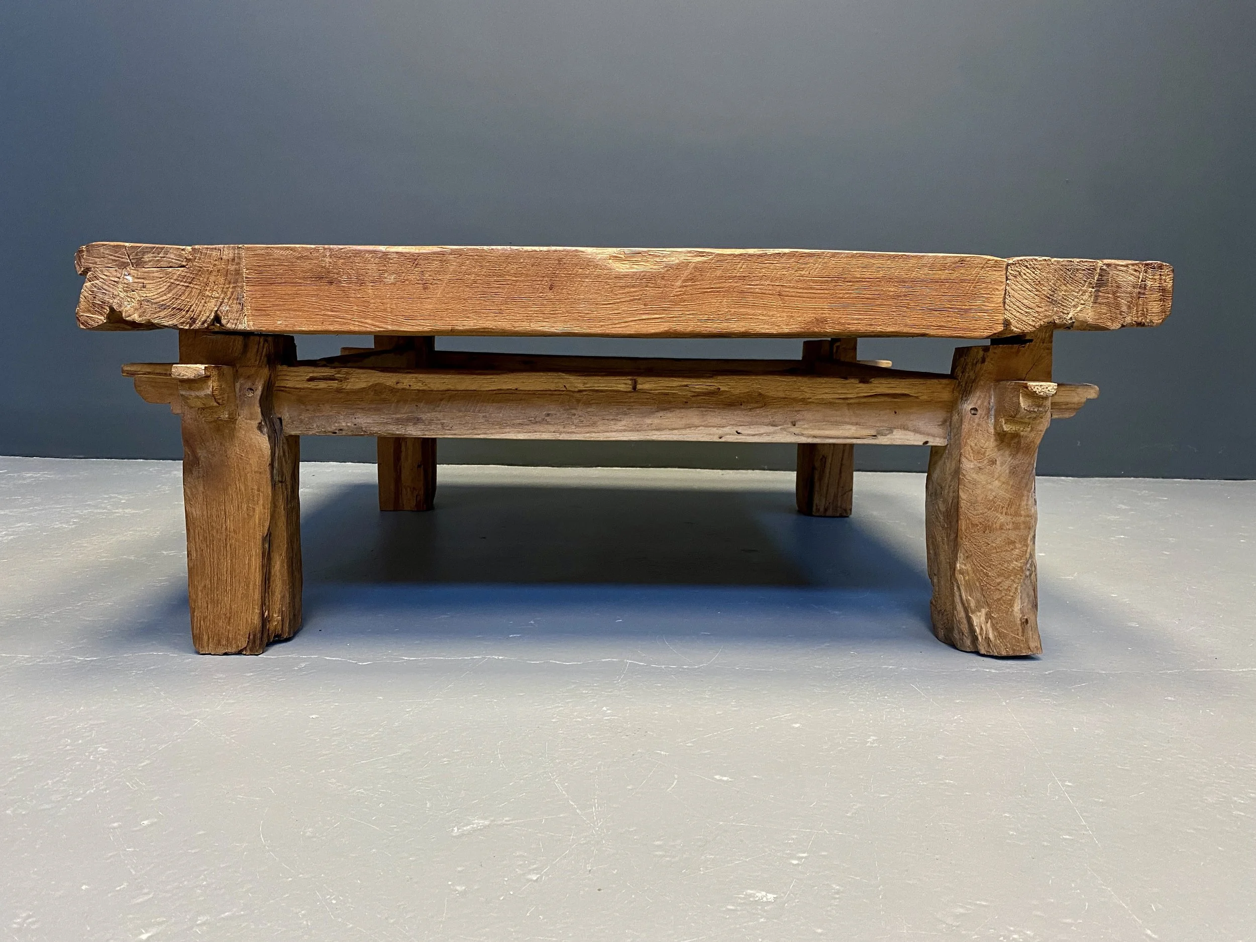 Brutalist solid oak coffee table with trapezoid legs and raw natural surface