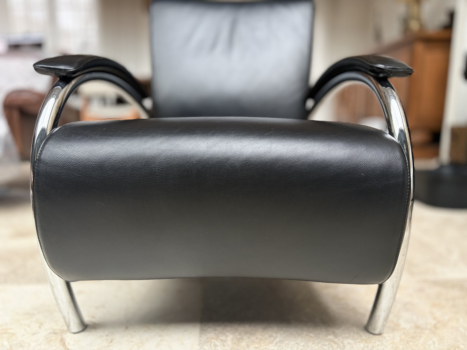 Dutch modernist lounge chair in black leather with sweeping chrome arc armrests and leather paddle arm pads
